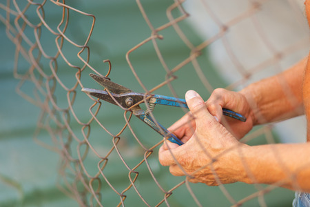 A man breaking down the fence with a cutter. Immigration conceptの写真素材