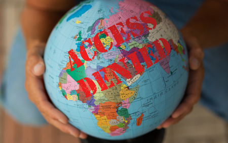 Globe in a manâs hand with a sign that reads âAccess deniedâの写真素材