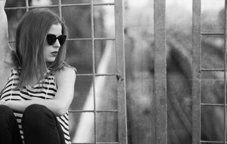 Lonely girl standing on the bridge. Toned imageの写真素材