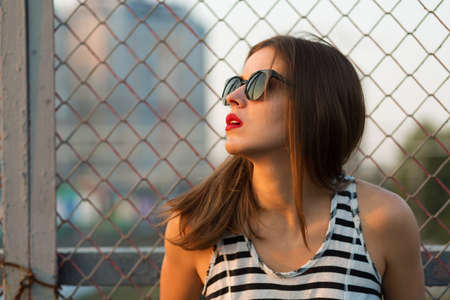 Lonely girl standing on the bridge. Toned imageの写真素材