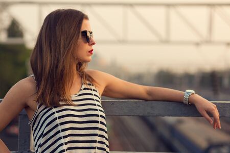 Lonely girl standing on the bridge. Toned imageの写真素材