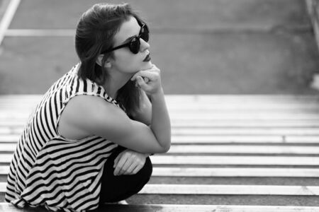 Lonely girl standing on the stairs. Black and white imageの写真素材