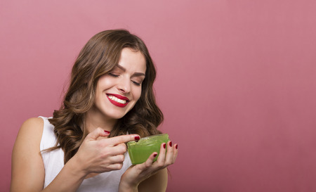 Pretty woman holding a bottle with face creamの写真素材