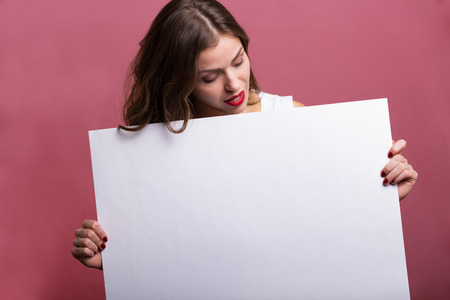 Beautiful woman holding a blank advertisement bannerの写真素材