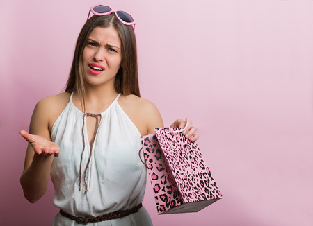 Pretty woman with pink glasses and shopping bagの写真素材