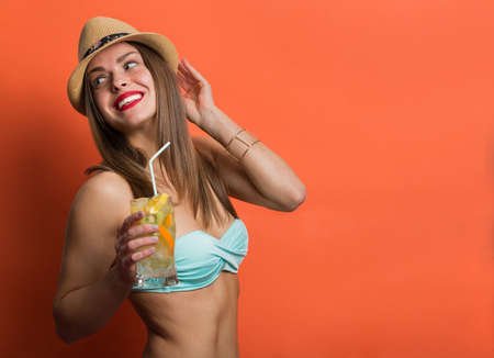 Pretty stylish girl in bikini holding cold drink