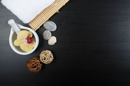 Beauty and spa treatment essentials on a dark wooden background