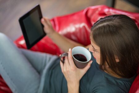 Woman reading a digital book at her home
