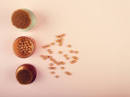 Face powder and bronzer makeup essentials on a pink backgroundの写真素材