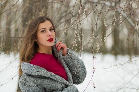 Beautiful woman in fur coat in the winter parkの写真素材