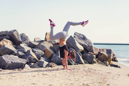 Woman practicing yoga at the summer beach