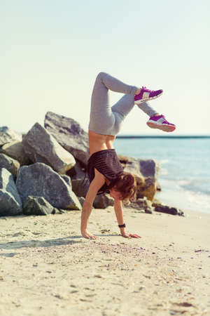 Woman practicing yoga at the summer beach