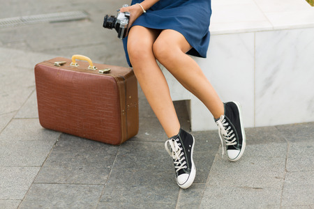 Pretty woman with a retro suitcase in the summer cityの写真素材