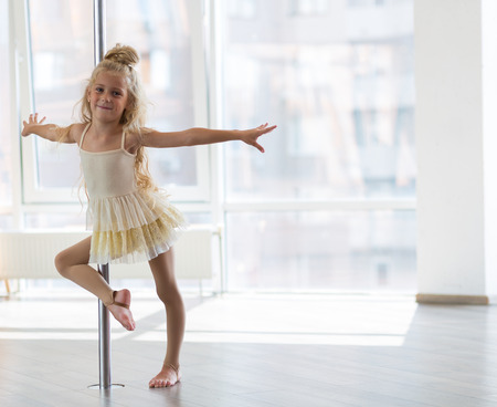 Beautiful little girl dancing in a dpole dance studioの写真素材