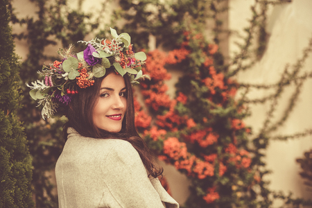 Pretty woman in a flower crown in an autumn gardenの写真素材