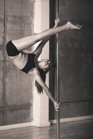 Pretty pole dancer girl working out in the studioの写真素材