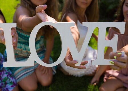 Young woman holding wooden 'Love' signの写真素材