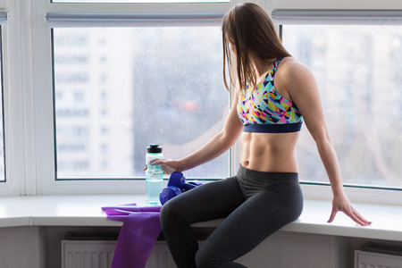 Beautiful young woman working out in the studio with elastic bandの写真素材
