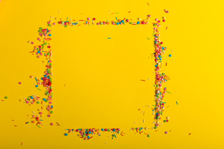 Colorful sprinkles on a yellow backgroundの写真素材