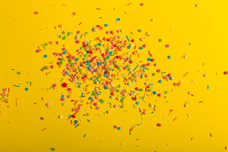 Colorful sprinkles on a yellow backgroundの写真素材