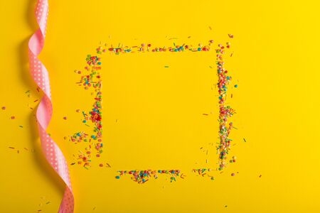 Colorful sprinkles on a yellow backgroundの写真素材