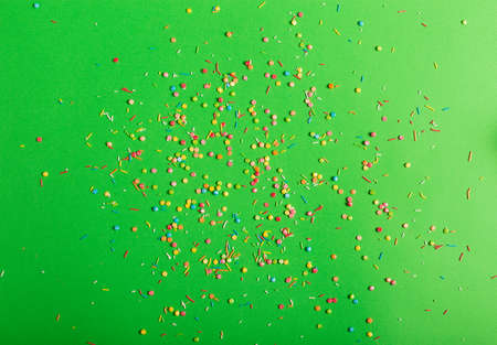 Colorful sprinkles on a green backgroundの写真素材