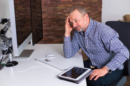 Senior caucasian man working in the modern officeの写真素材