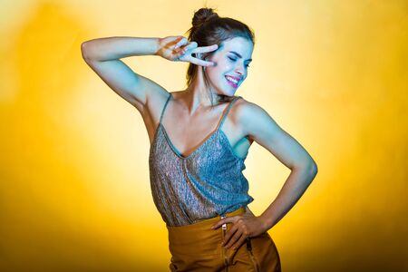 Beautiful woman dancing and posing in bright disco lightsの写真素材