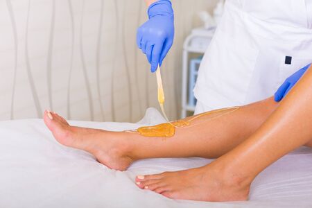 Woman cosmetologist working with sugar paste in a spa salonの素材 [FY31087671686]