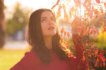 Beautiful woman walking alone in the autumn parkの写真素材