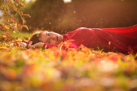 Beautiful woman walking alone in the autumn parkの写真素材