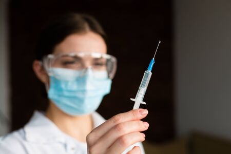Woman doctor holding a syringe with a vaccine