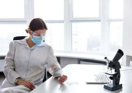 Woman doctor working in the lab at the laptopの写真素材