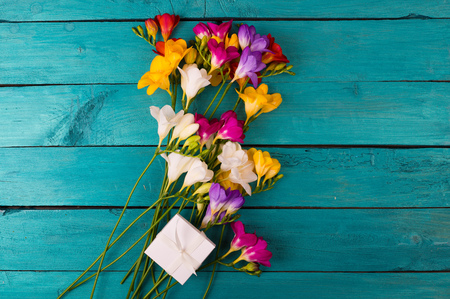 Bouquet of freesia flowers on a blue wooden backgroundの写真素材