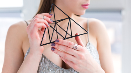 Beautiful young woman daydreaming by the windowの写真素材