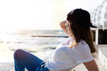 Beautiful yound woman with a skateboard on a beachの写真素材