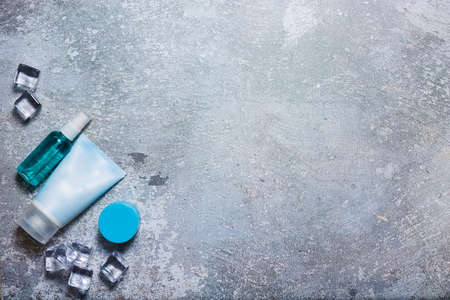 Cosmetics on a concrete background with ice cubesの写真素材