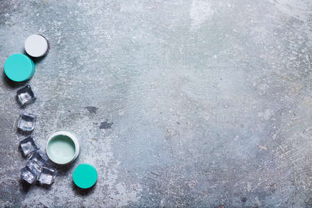 Cosmetics on a concrete background with ice cubesの写真素材