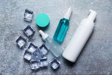Cosmetics on a concrete background with ice cubesの写真素材