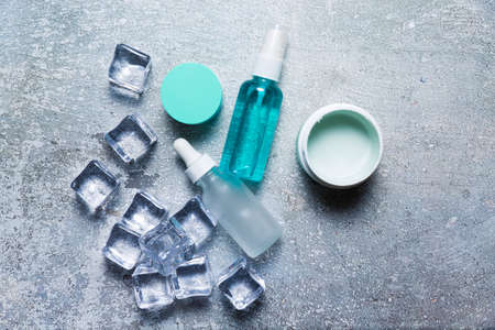 Cosmetics on a concrete background with ice cubesの写真素材