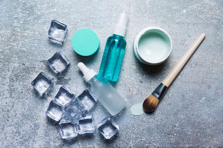 Cosmetics on a concrete background with ice cubesの写真素材