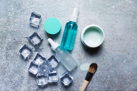 Cosmetics on a concrete background with ice cubesの写真素材