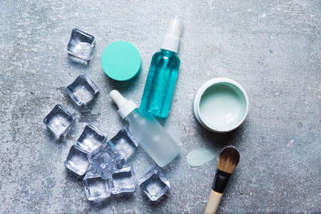 Cosmetics on a concrete background with ice cubesの写真素材