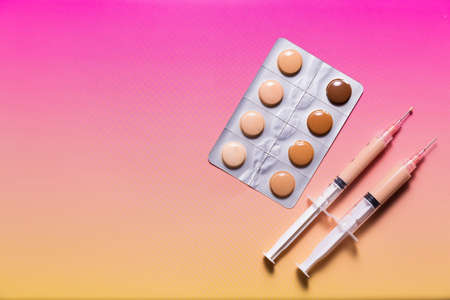 Pills in a blister pack and syringes filled with makeup concealer and foundation. Perfect skin conceptの写真素材