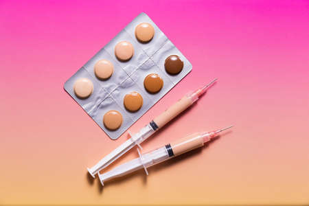 Pills in a blister pack and syringes filled with makeup concealer and foundation. Perfect skin conceptの写真素材
