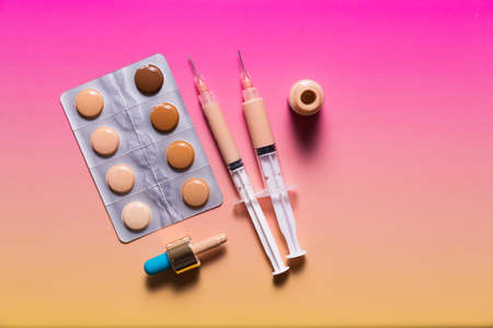 Pills in a blister pack and syringes filled with makeup concealer and foundation. Perfect skin conceptの写真素材