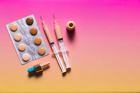 Pills in a blister pack and syringes filled with makeup concealer and foundation. Perfect skin conceptの写真素材