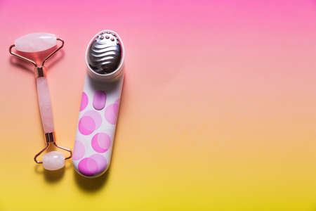 Set of various facial massagers on bright pink ombre backgroundの写真素材
