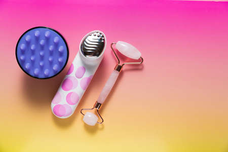 Set of various facial massagers on bright pink ombre backgroundの写真素材