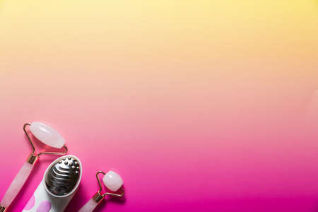 Set of various facial massagers on bright pink ombre backgroundの写真素材